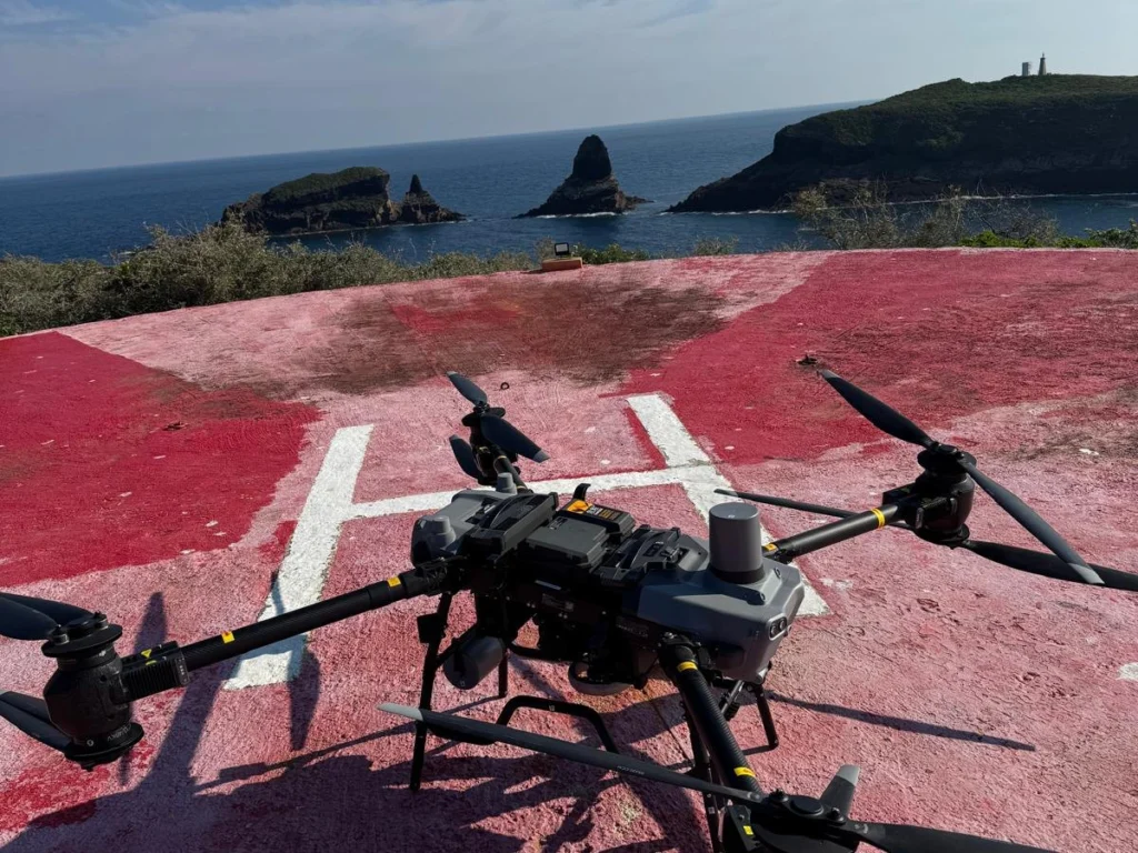 DJI FlyCart 30 en el helipuerto de la isla de Columbretes, con los islotes y el faro al fondo