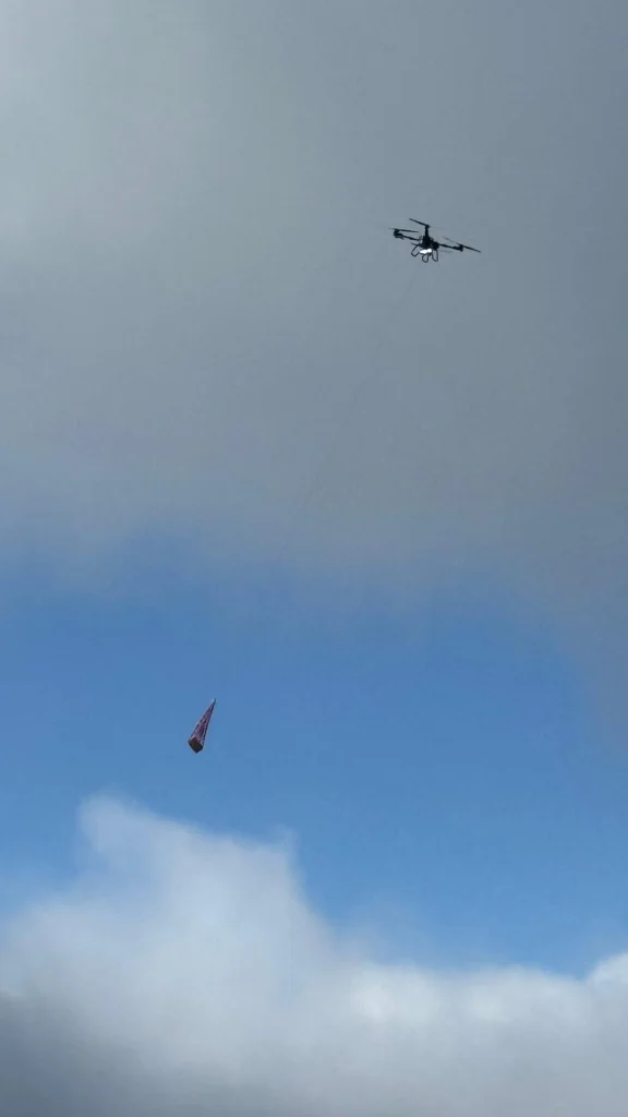 DJI FlyCart 30 elevando un poste de señalización con el cabrestante en la Sierra de Tramuntana